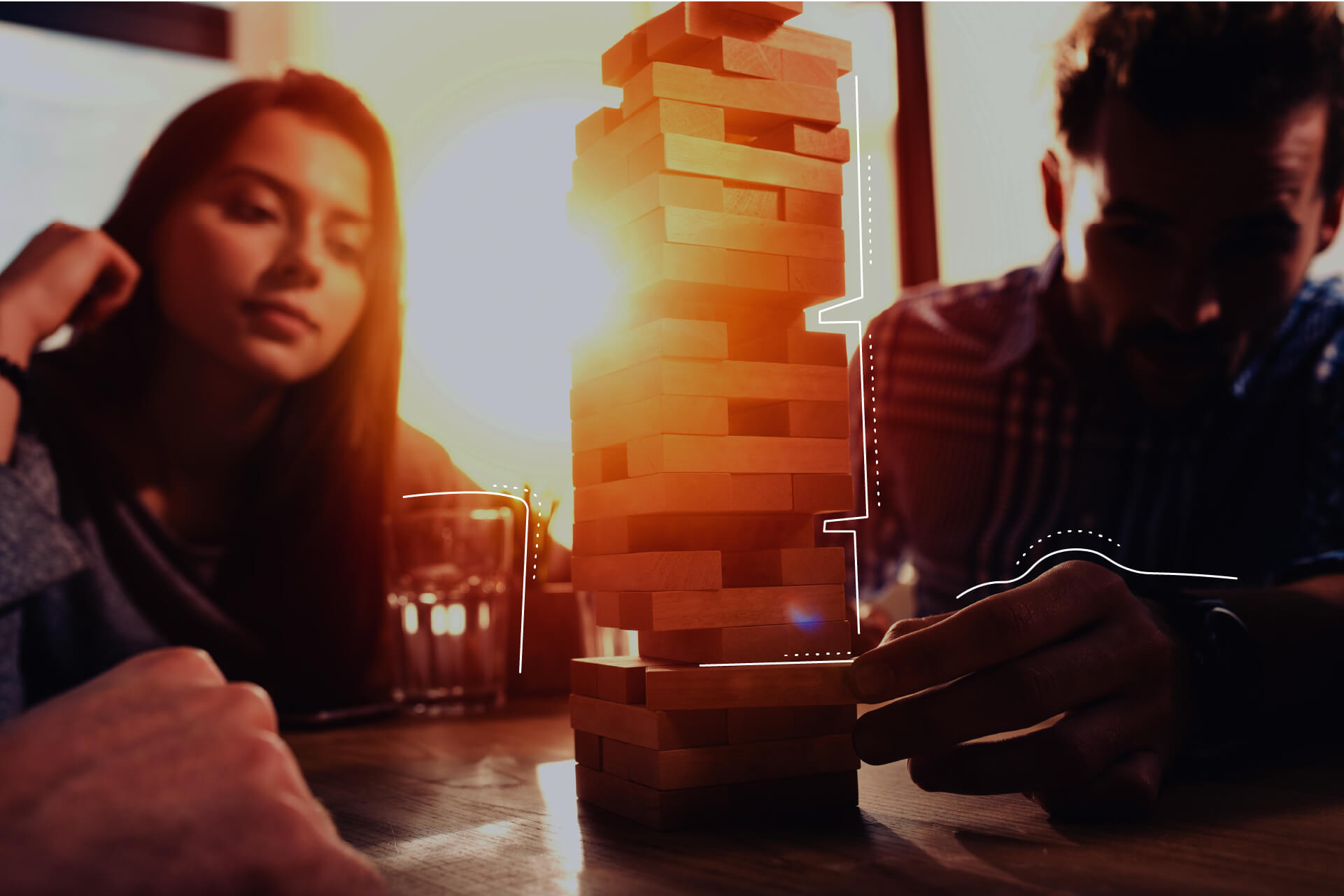 Personen die im Abendlicht eine Partie Jenga spielen. | eggheads.net