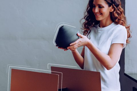Frau packt Objekt aus Paket aus | eggheads.net
